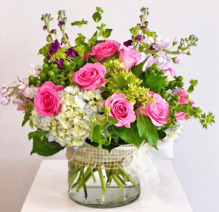 Fresh from the garden and wrapped in ribbon, this cylinder of the seasons best blooms makes a perfect statement.