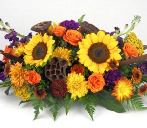 sunflowers adn orange and yellow flowers in arrangement